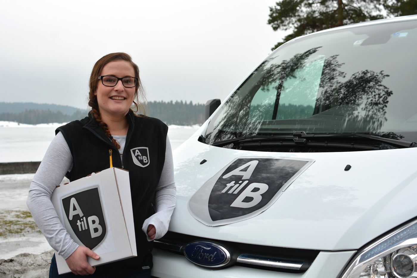 Sjåfør fra A til B med en pakke ved fronten av varebilen